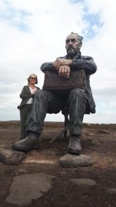 Photograph of a woman standing next to one of the many statues that you come across on walks around the local area